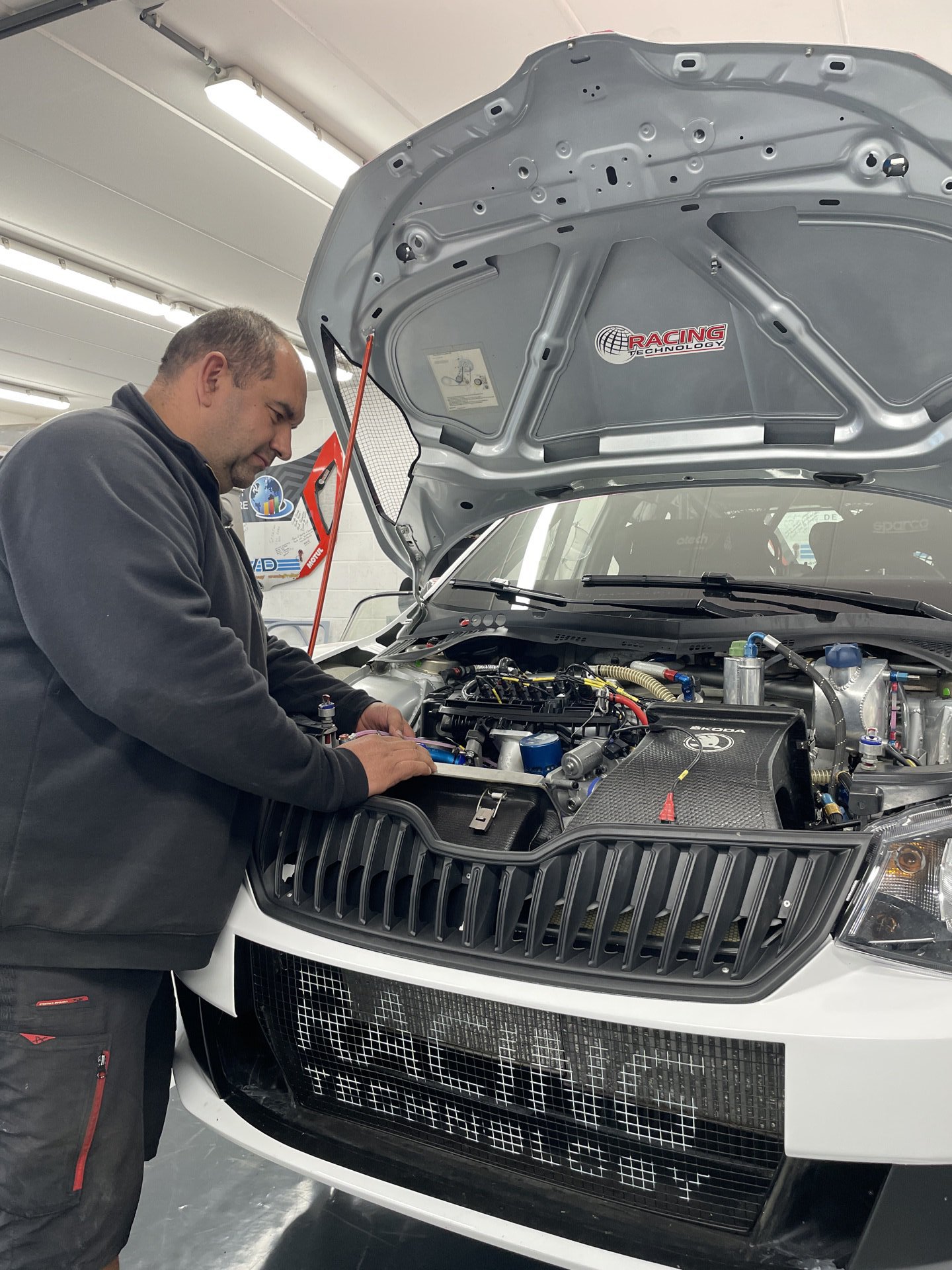 Cédric Lefèvre penché sur le moteur d’une voiture à l’atelier
